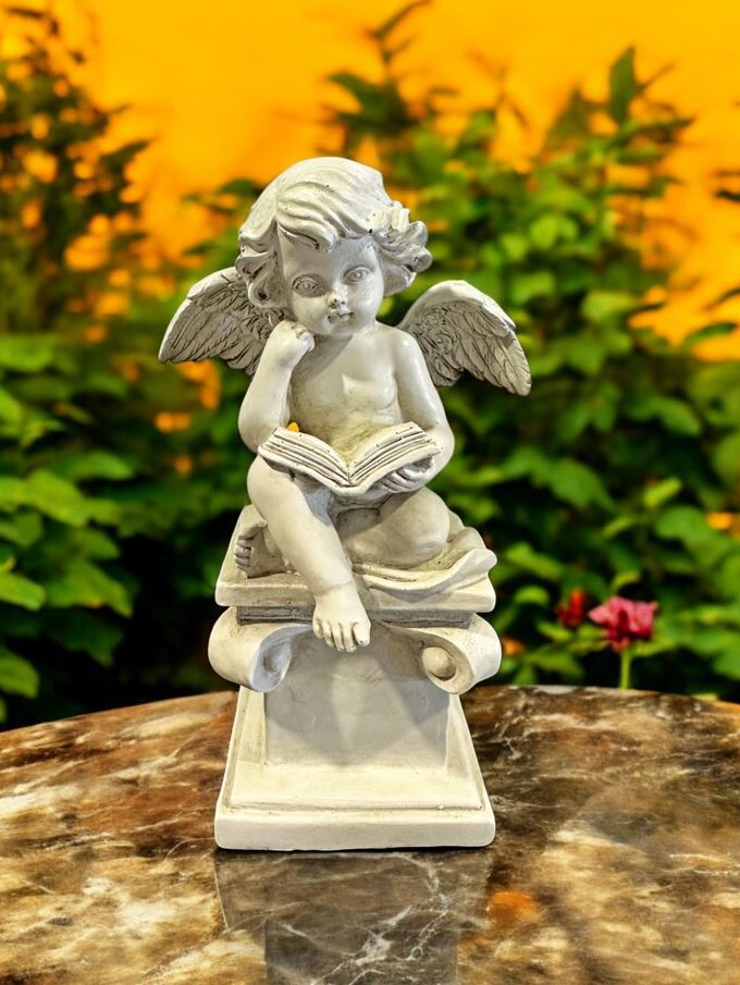 Engelfigur sitzend auf Stein mit Buch in Grau