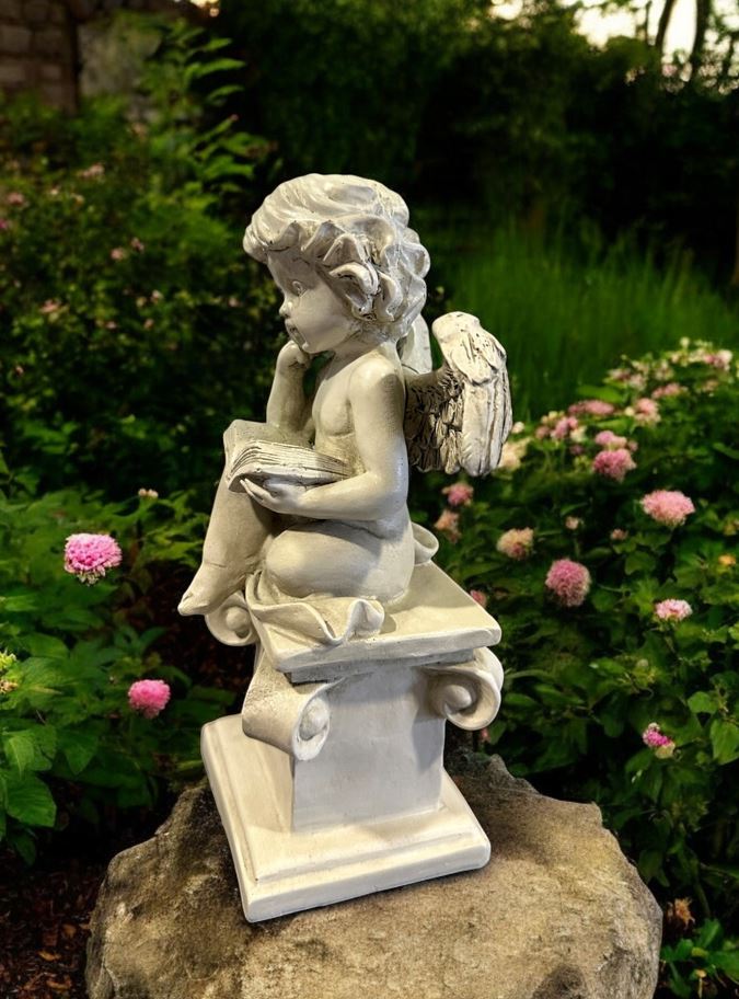 Engelfigur sitzend auf Stein mit Buch in Grau