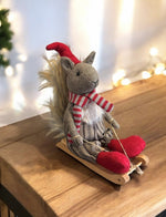 Deko Eichhörnchen auf Schlitten braun weiss mit roter Mütze