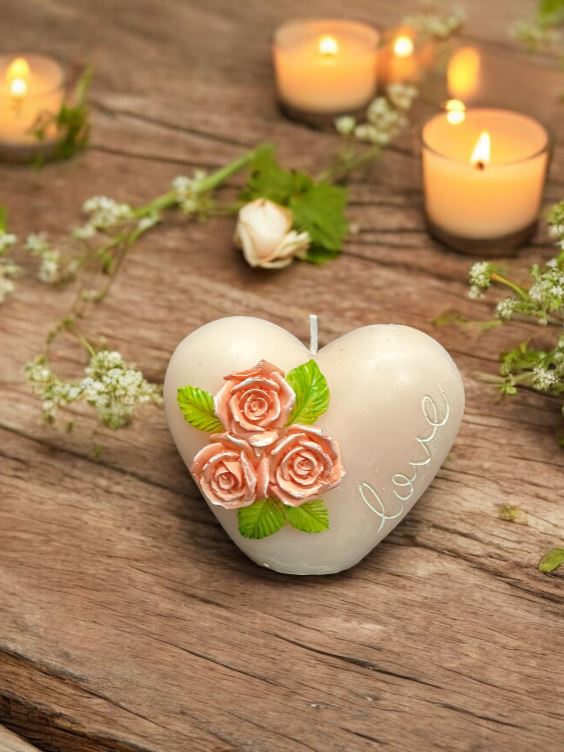 Kerze in Herzform mit kleinen Rosen verziert in Geschenksverpackung