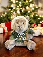 Deko Bär sitzend grün mit Kapuze und Ski in der Hand