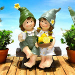 Dekofiguren Kinder sitzend auf Bank mit Zitronen