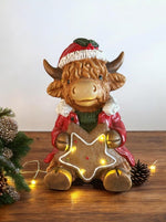 LED Deko Hochlandrind mit 4 LED sitzend mit Stern in der Hand